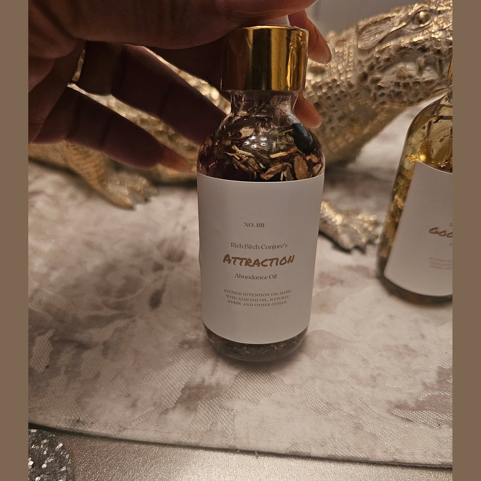 Rich Bitch Conjure Deadly Attraction Hoodoo Oil in a small glass bottle, used for magnetism, love, money, and favor rituals.
