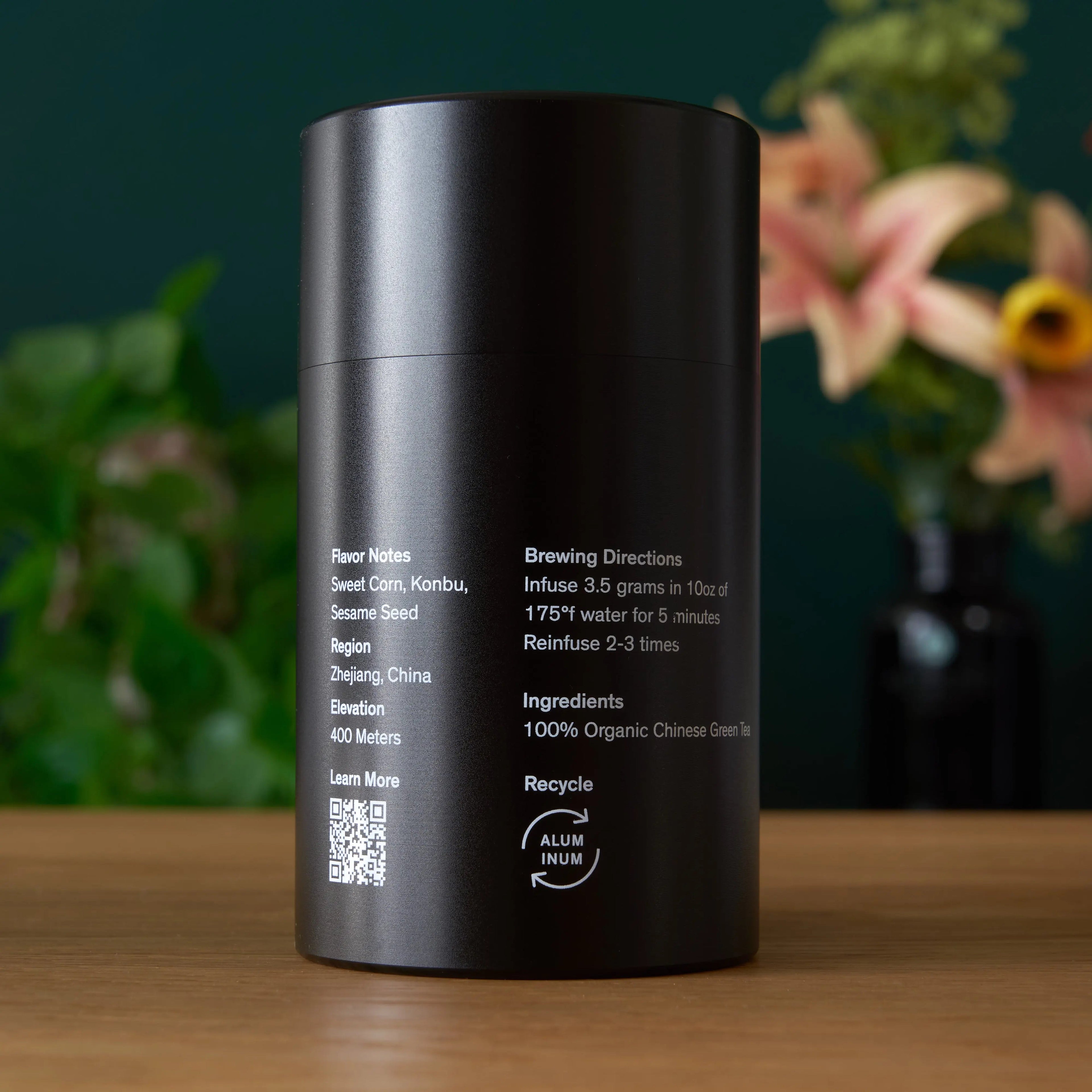 Single estate Pi Lo Chun green tea from Rare Leaves Emerald by August Uncommon Tea, featuring fresh green tea leaves in a tin container.