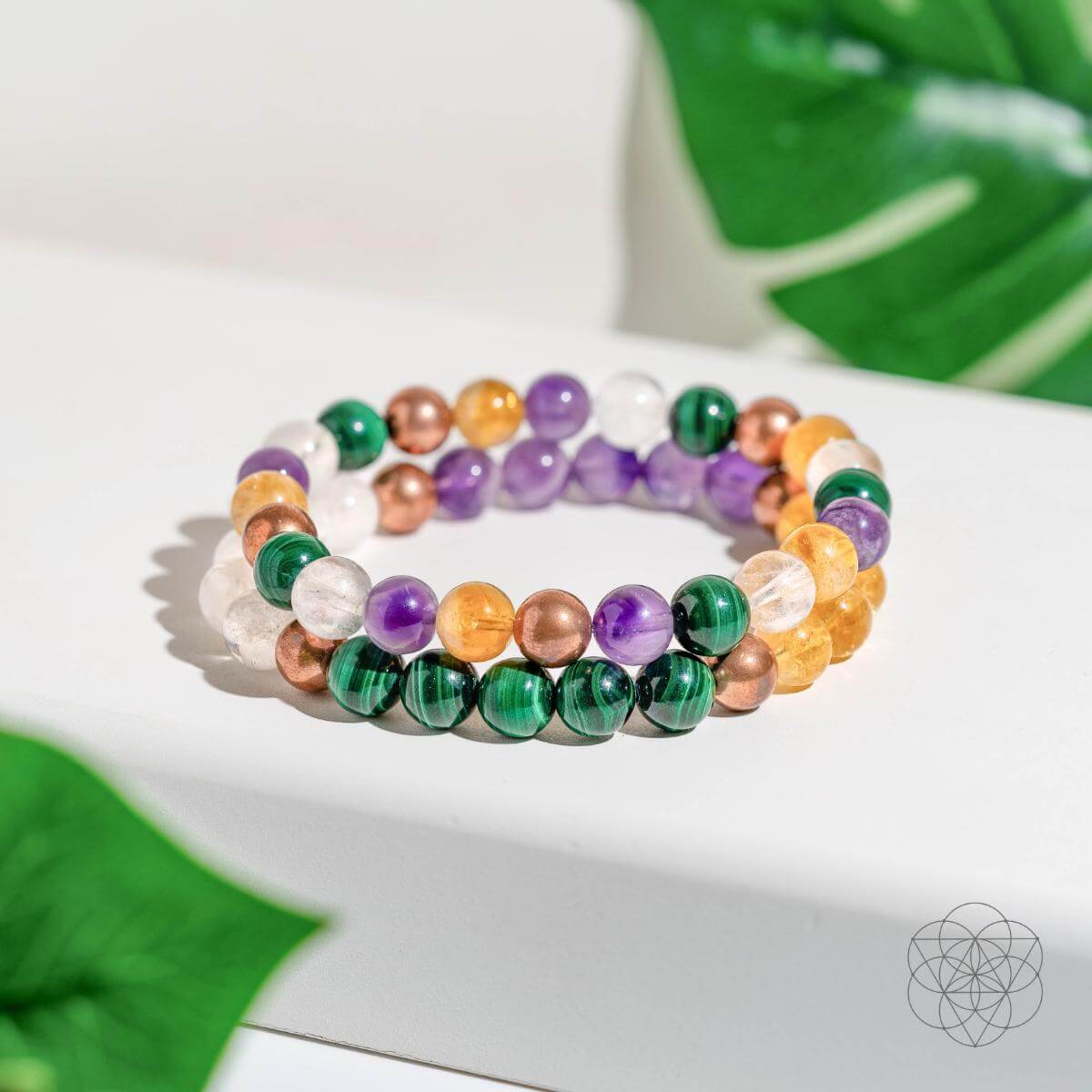 Set of four crystal bracelets for wealth manifestation by Conscious Items, featuring polished gemstone beads in vibrant colors.