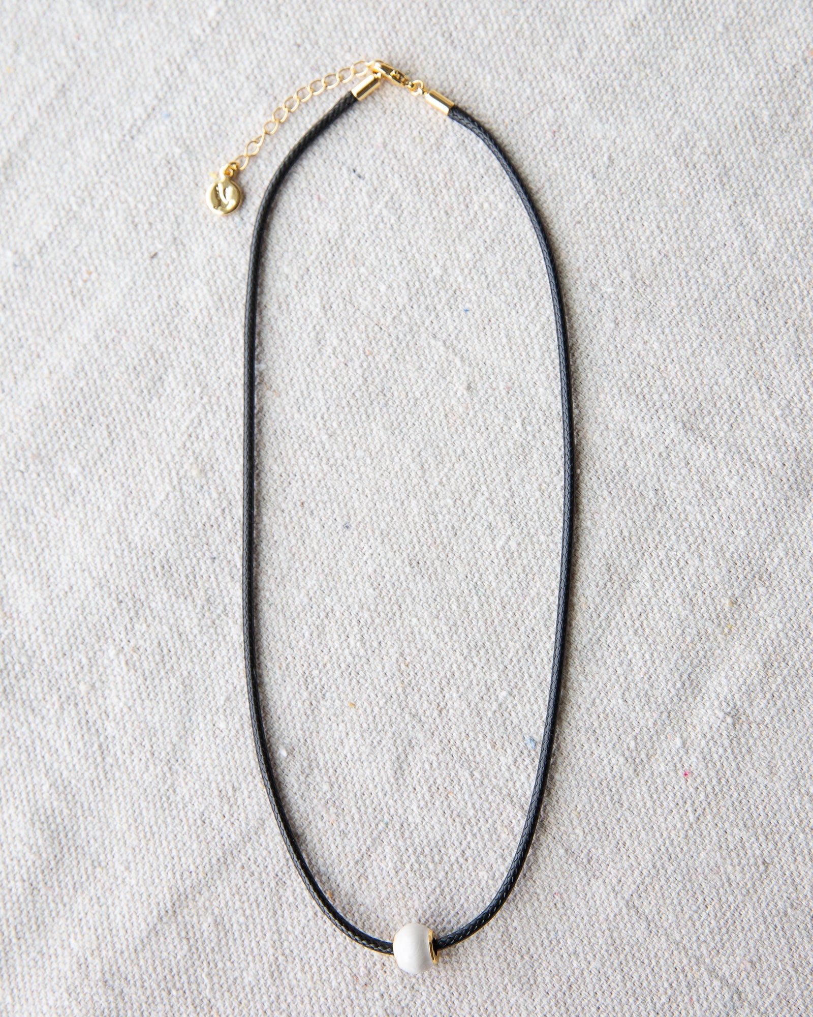 Downeast pearl and cord necklace featuring a string of white pearls on a black cord, stylish and elegant jewelry accessory.