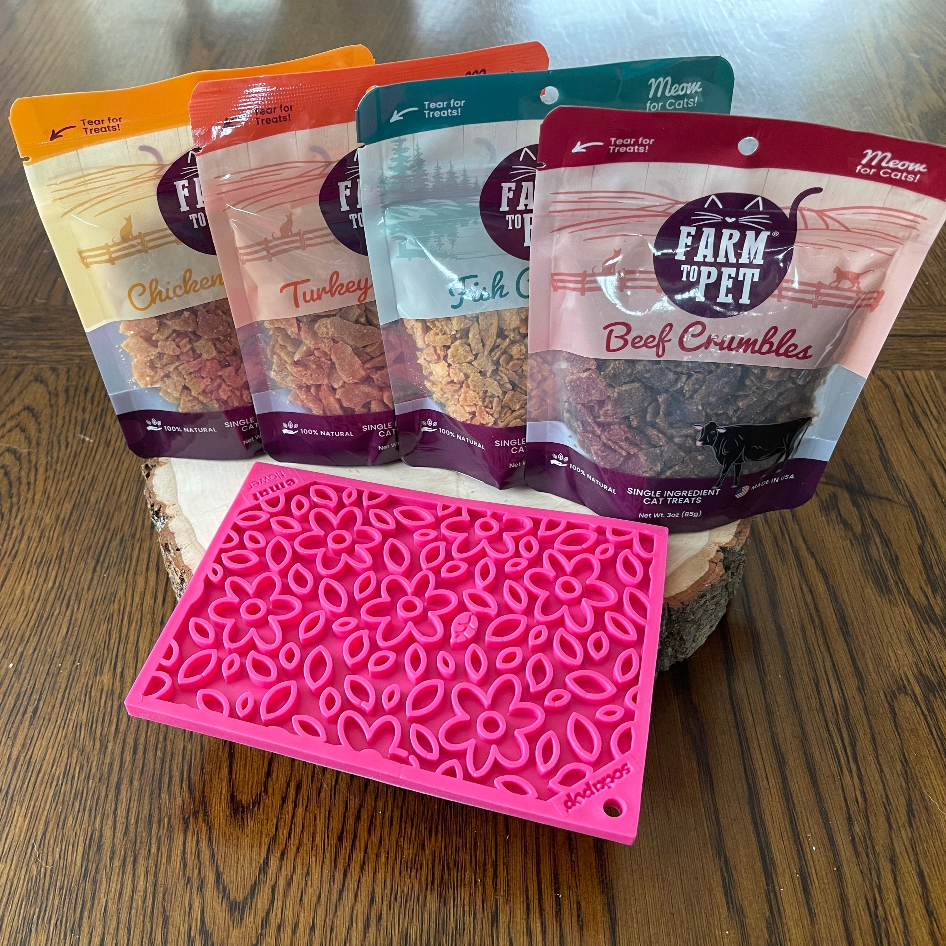 Farm To Pet chicken crumble cat treats on pink flower lick mat, single-ingredient treats for cats with chicken flavor.