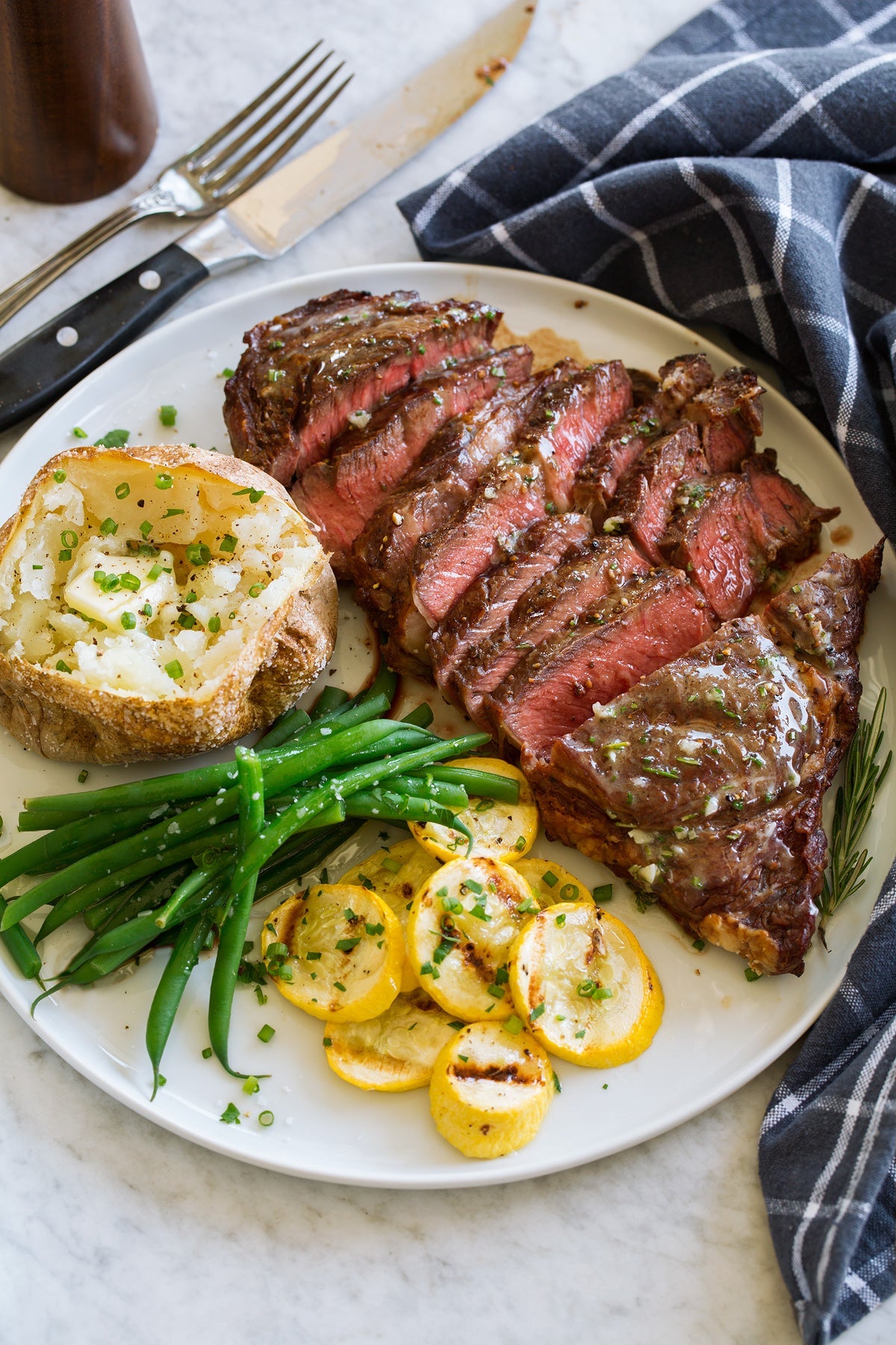 Igotchu Steak Seasoning jar with seasoning blend for enhancing grilled and cooked steaks, shown on a rustic wooden surface.