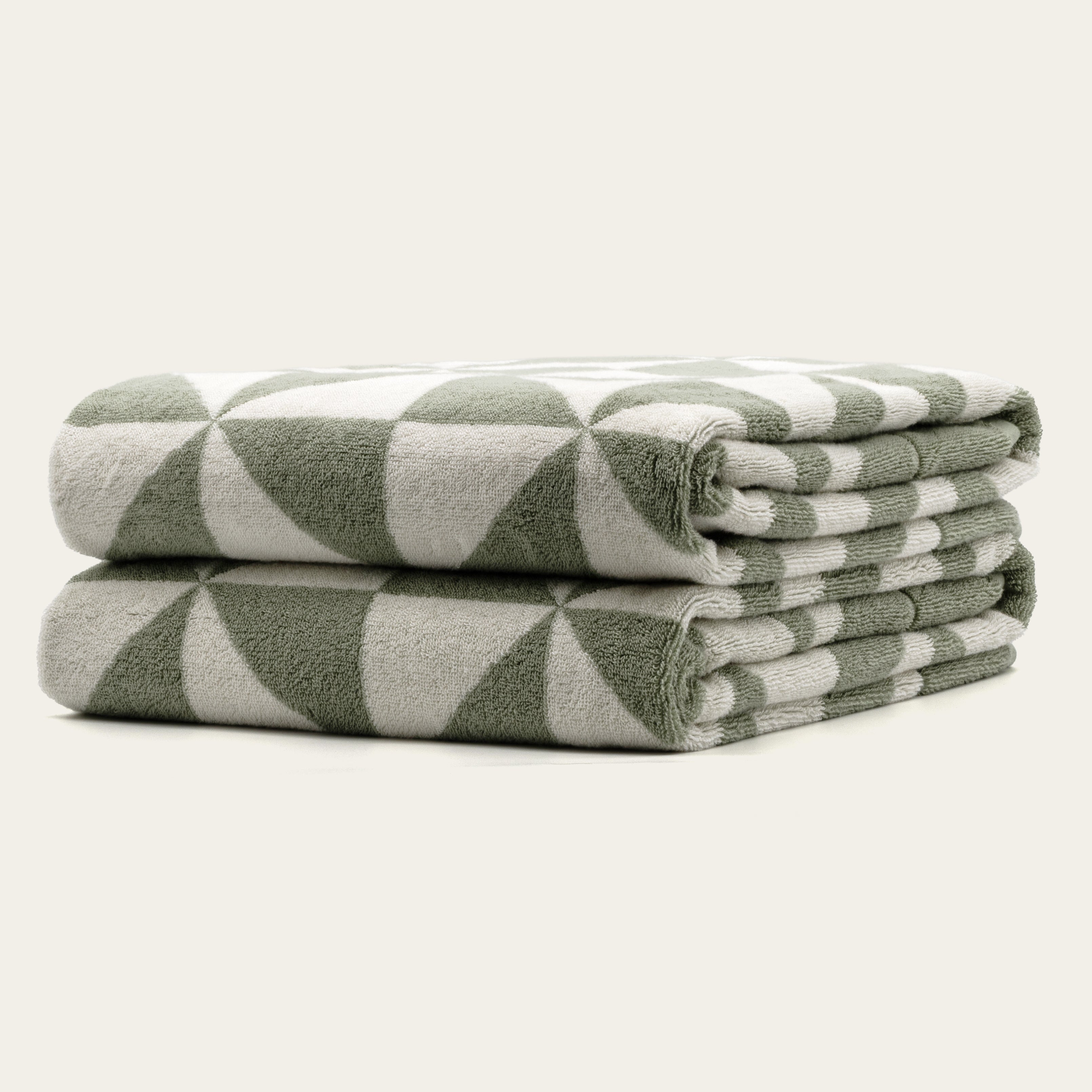 Italic Umbra Australian Cotton Bath Towels, soft and plush, shown folded on a bathroom shelf in natural lighting.