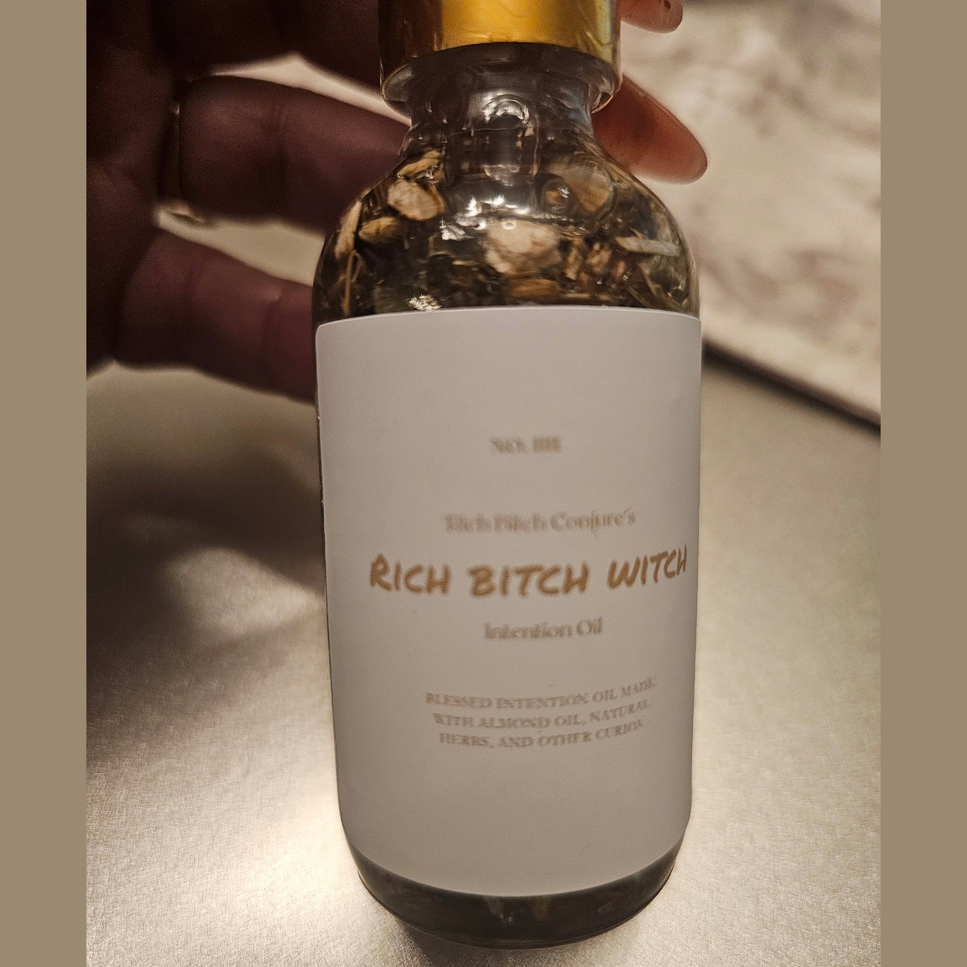 Rich Bitch Conjure Hoodoo Oil bottle labeled Rich Witch Bitch Intuitive Oil with mystical packaging and dark aesthetic.
