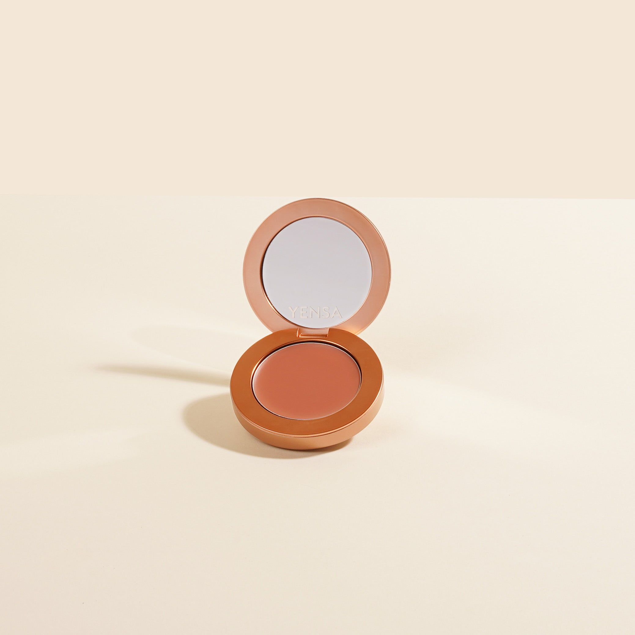 YENSA Super Serum Silk Buildable Cream Blush in Ginger Blaze, featuring a smooth, blendable coral-orange shade in a compact container.
