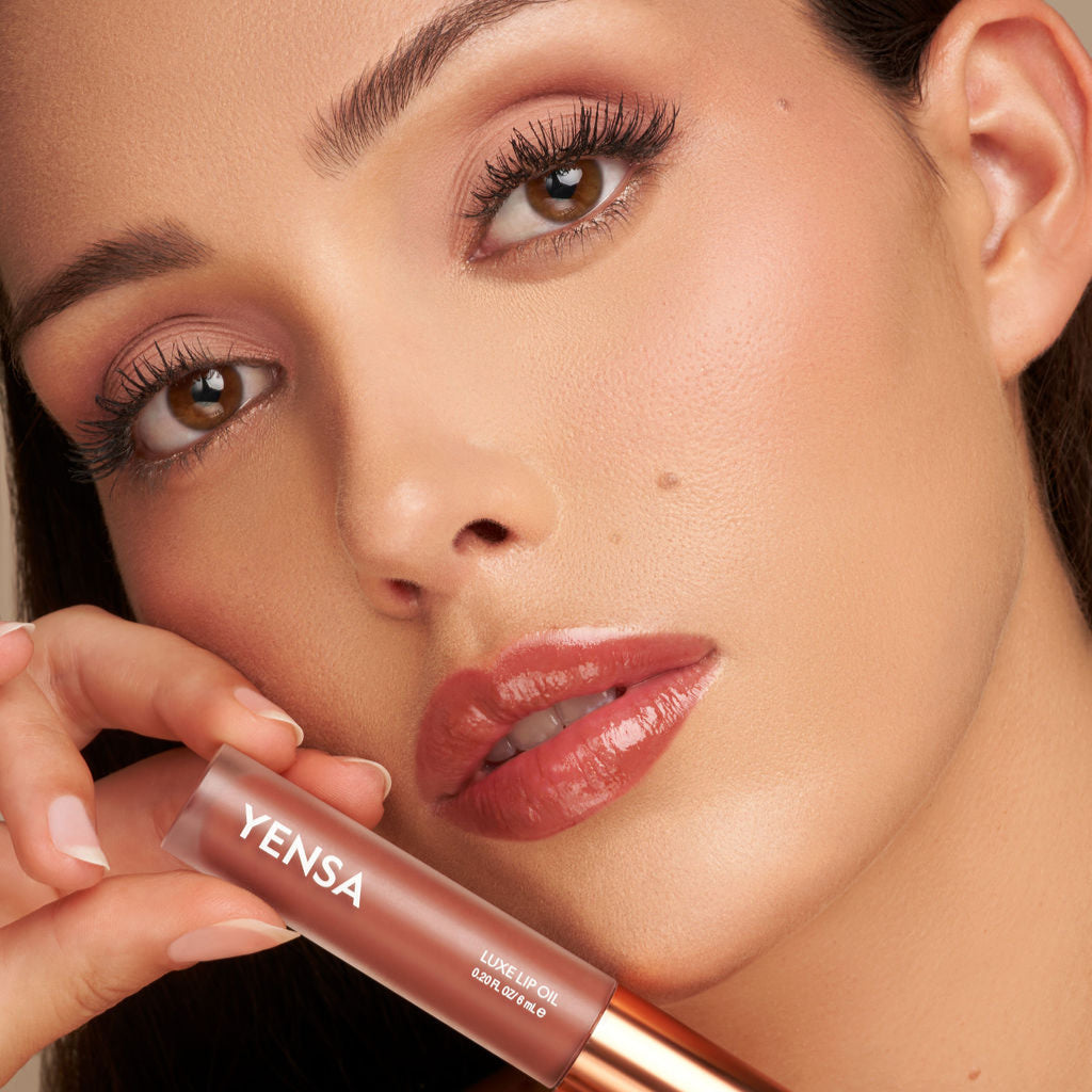 YENSA Luxe Lip Nourishing Oil with hyaluronic and vitamin E, showing a sleek lip oil applicator and modern nude lip look.