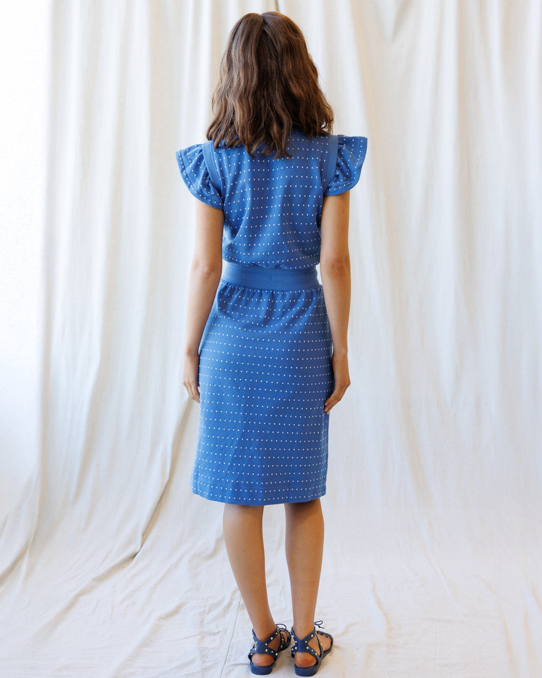 Downeast On Repeat Dress in a flowy, patterned fabric with long sleeves and a relaxed fit, displayed on a hanger.