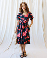 Downeast Signature Sun Dress, sleeveless summer dress with floral pattern and lightweight fabric, hanging on a wooden hanger.