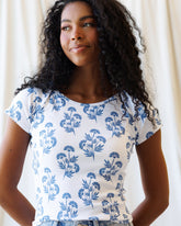 Downeast Artistic Tee tops, featuring a colorful abstract design on soft fabric, displayed on a hanger.