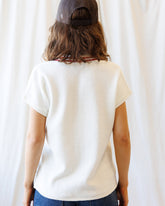 Downeast Atlantic vest, a cozy sweater with a textured knit pattern, in a neutral color, displayed on a hanger.