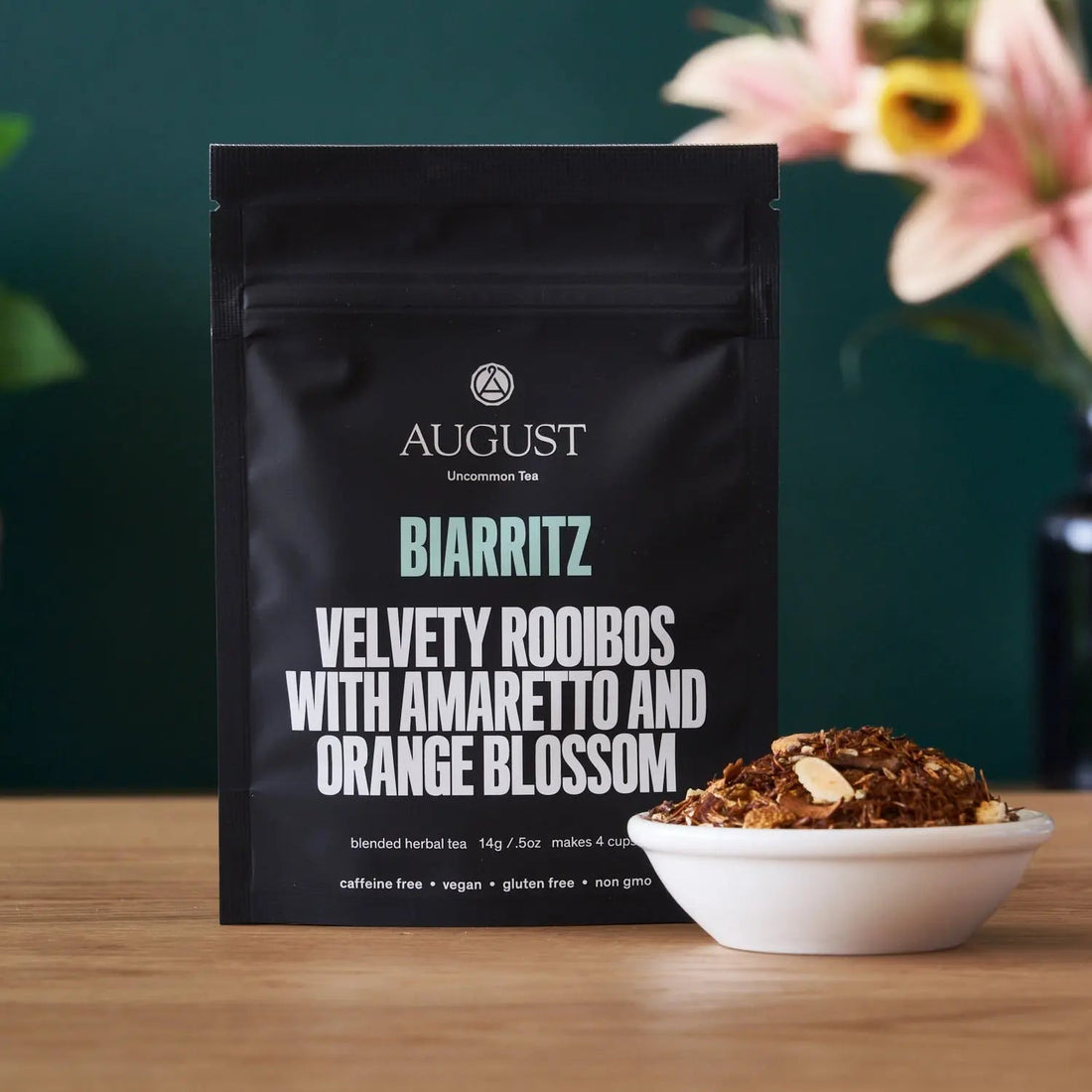 Biarritz Orange Amaretto Rooibos Tea by August Uncommon Tea, caffeine-free herbal tea in a cup with vibrant orange and amber colors.