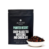 Four cups of Painted Desert Chocolate Chili Black Tea by August Uncommon Tea, showcasing dark brewed black tea in glass cups.