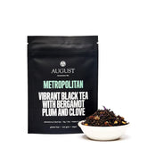 Four cups of August Uncommon Tea Metropolitan Bergamot Plum Earl Grey black tea served in clear glass cups.