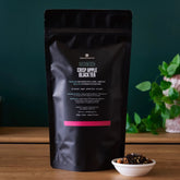August Uncommon Tea Mackintosh Crisp Apple Black Tea in a 70-cup tea bag, vibrant black tea with apple flavor, ready for brewing.