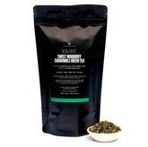 Neon Forest Apple Chamomile Green Tea bag from August Uncommon Tea, bright green tea leaves in a sealed bag for brewing.