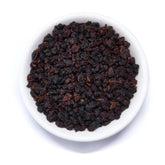 Dark roasted Taiwanese oolong tea leaves from Rare Leaves Black Pearl by August Uncommon Tea, showcasing glossy, tightly rolled dark leaves.