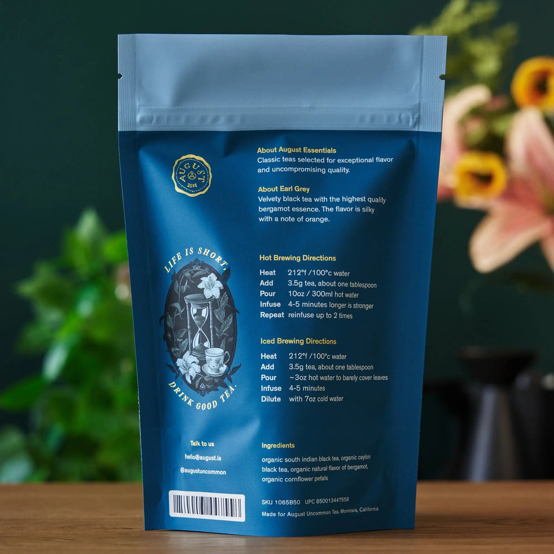 Essentials Earl Grey black tea in a 15-cup bag, brewed and steaming in a white mug, from August Uncommon Tea.
