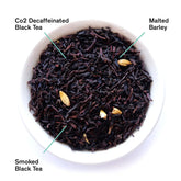Decaf Low Country Bourbon Sugar Black Tea by August Uncommon Tea, showing a brewed black tea in a glass cup with tea leaves.