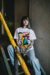 White Betrayal T-Shirt by Any Means Necessary Clothing featuring a graphic design on the front.