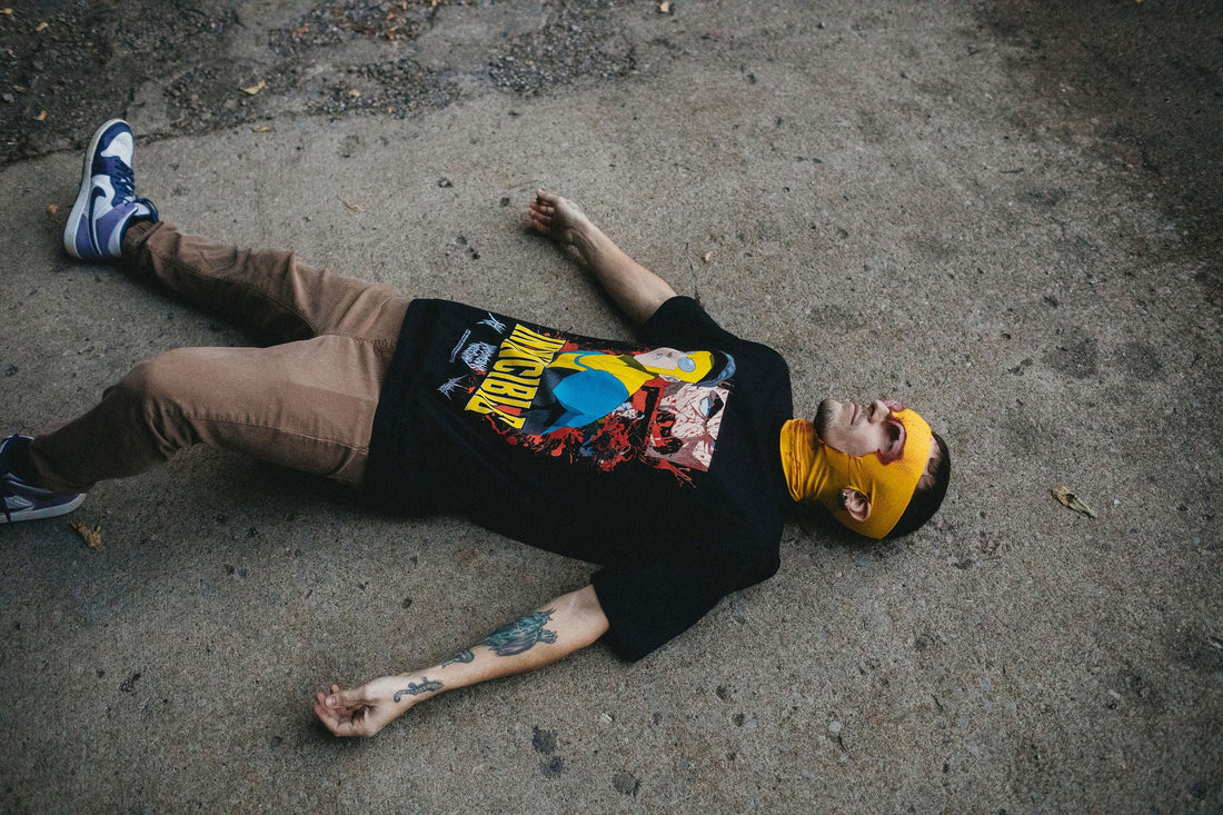 Black Betrayal T-Shirt from Any Means Necessary Clothing featuring a modern graphic design on the front.