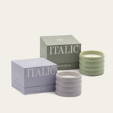 Set of two Italic soy wax ceramic candles with white ceramic holders, showcasing clean, minimalist design and soft candlelight.