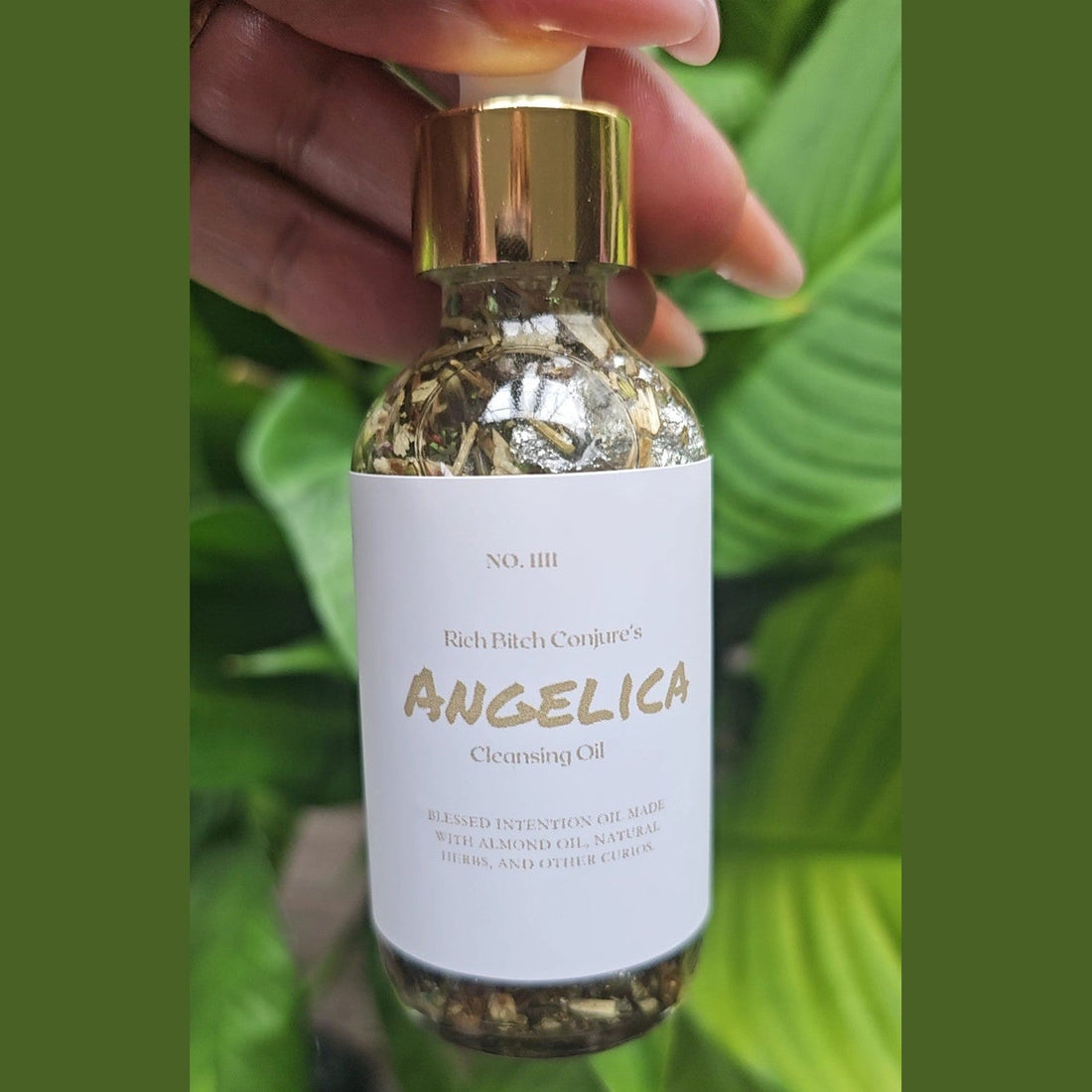 Rich Bitch Conjure Angelica Cleansing Oil, hoodoo oil with herbal ingredients, in a clear glass bottle with dropper cap.
