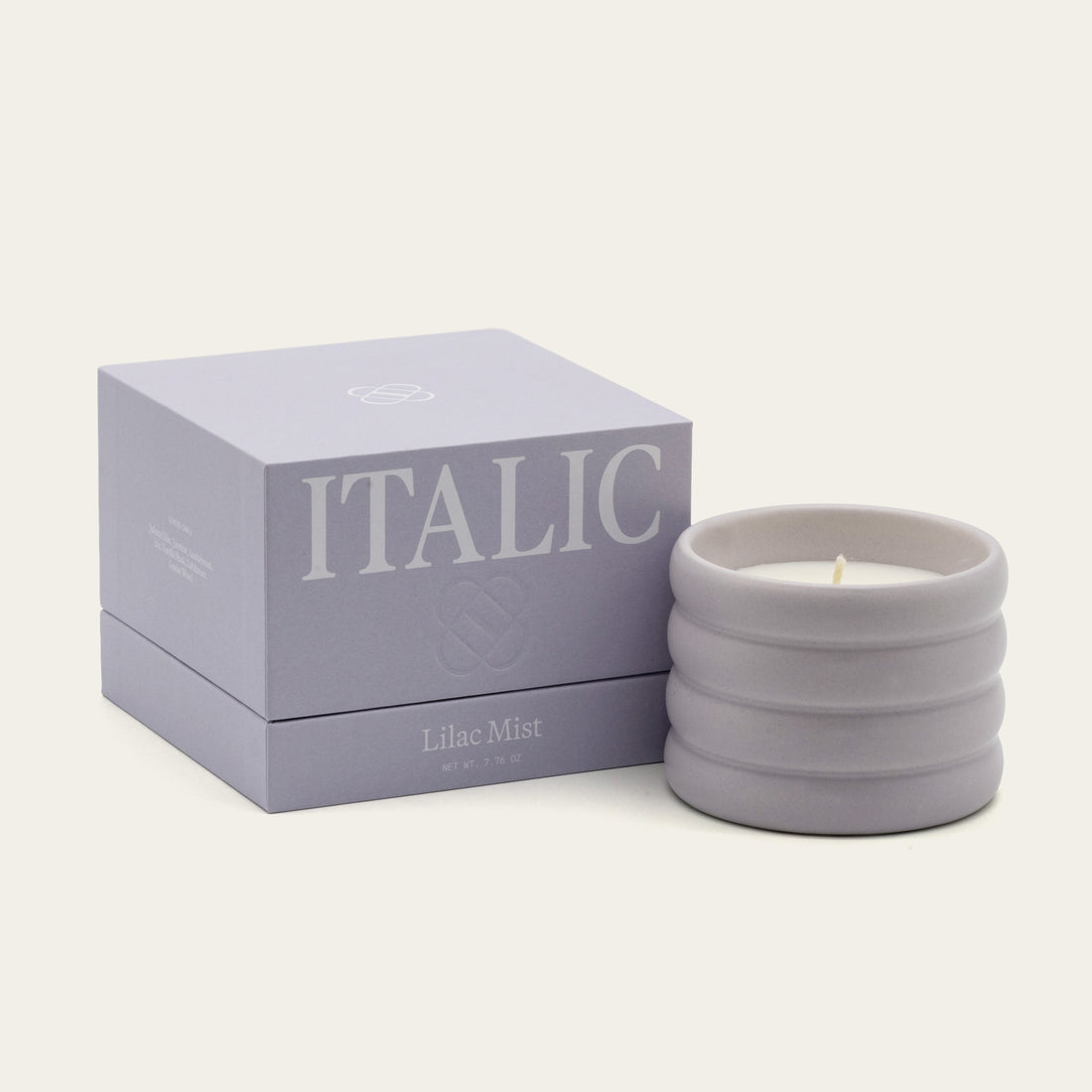 Soy wax ceramic candle by Italic, showing a white ceramic container with a lit wick and natural soy wax interior.