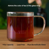 Clear glass mug from August Uncommon Tea, showcasing elegant teaware design with a smooth handle and transparent body.