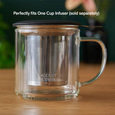 Clear glass mug from August Uncommon Tea, elegant teaware with a smooth handle and transparent design for enjoying hot beverages.