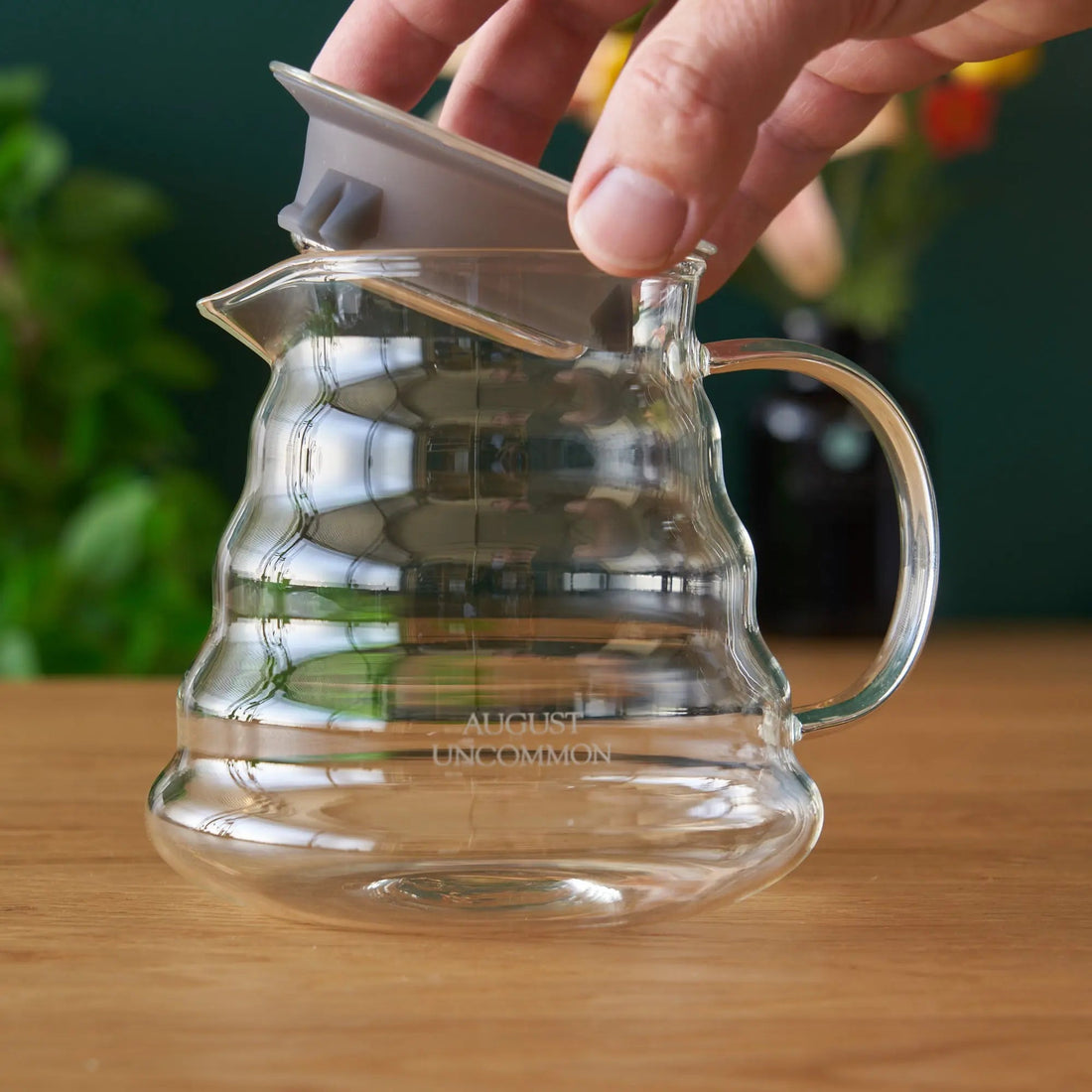 Two cup glass teapot by August Uncommon Tea, clear teaware with a sleek design for brewing and serving tea.