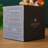 Two cup glass teapot by August Uncommon Tea, clear teaware with a sleek design for brewing and serving tea.