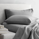 Smooth Luxe Australian Sateen Sheet Set by Italic on a bed with neatly arranged sheets and pillowcases in a cozy bedroom setting.