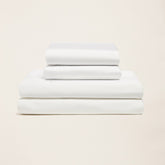 Italic Luxe Australian Sateen Sheet Set displayed on a bed with smooth, shiny satin fabric and neatly arranged pillows.