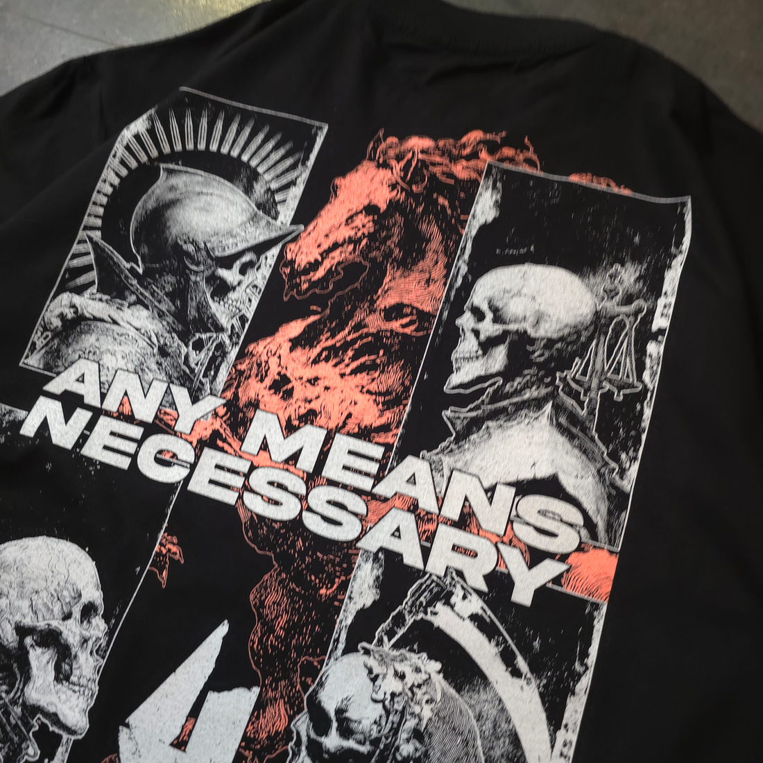 Black "4 Horsemen" T-shirt from Any Means Necessary Clothing, front close-up showing bold graphic design and classic fit.