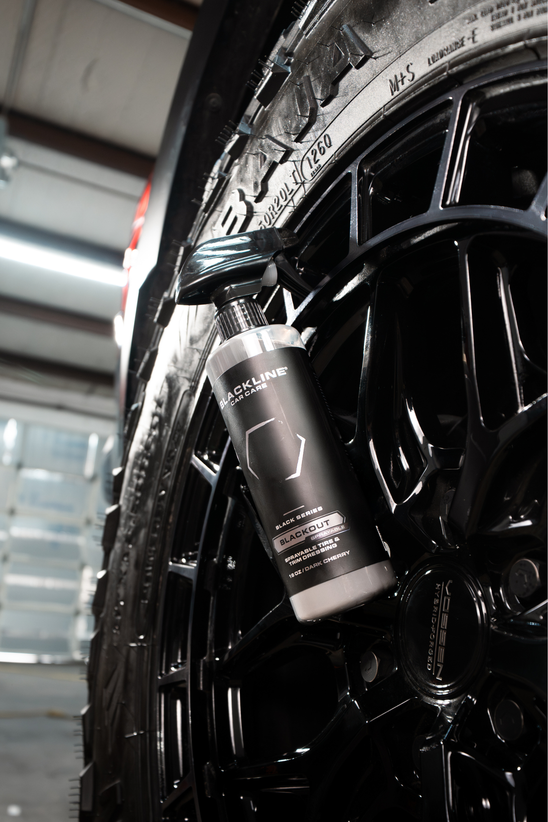 Blackline Car Care BLACKLINE® Blackout Trim and Tire Dressing applied to car tires and trim for a sleek, shiny finish.