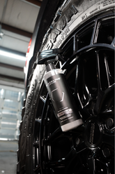 Blackline Car Care BLACKLINE® Blackout Trim and Tire Dressing applied to car tires and trim for a sleek, shiny finish.