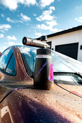 Blackline Car Care BLACKLINE® Ultra Series Foam Cannon attached to a hose, producing thick foam for car washing.