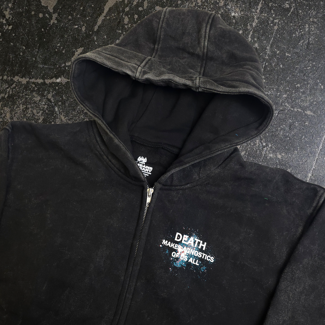 Black Agnostic zip-up hoodie by Any Means Necessary Clothing, shown from the back with a close-up view of the hood and zipper.
