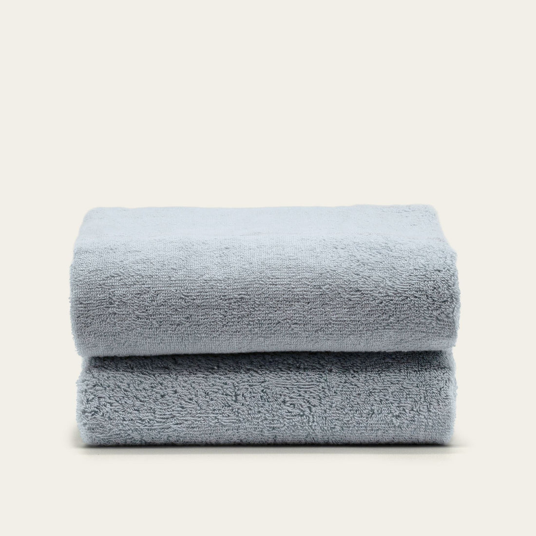 Soft white Deia Australian cotton towel from Italic, displayed on a bed, showcasing its plush texture and high-quality fabric.