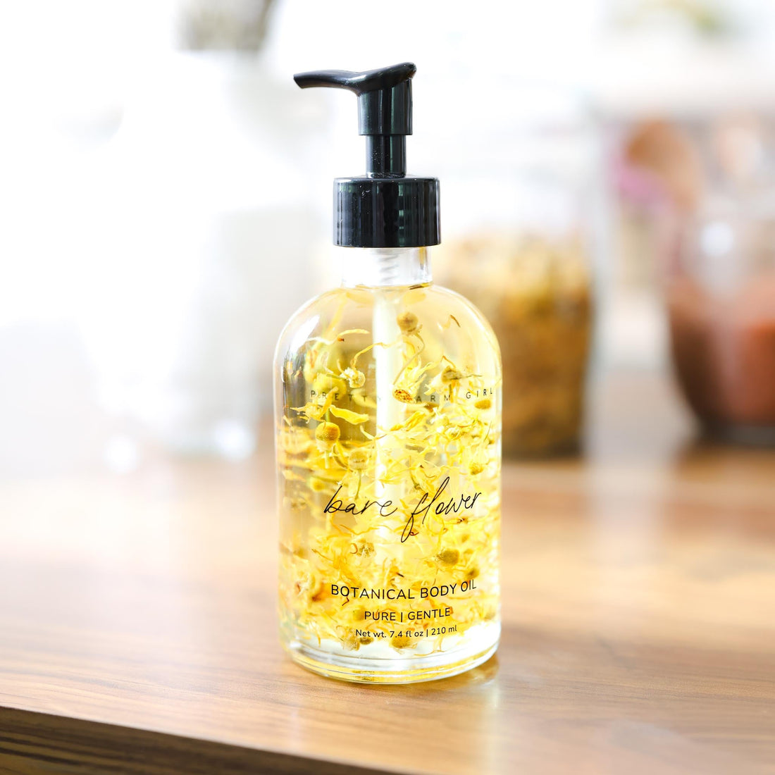 Bare Flower fragrance-free body oil by Pretty Farm Girl, showing a sleek bottle of health and beauty skincare product.