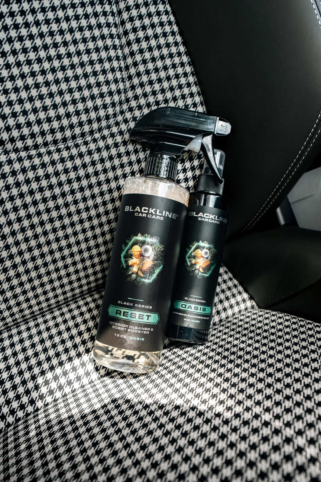 Blackline Car Care BLACKLINE® Reset interior cleaner and scent booster bottle beside a Porsche vehicle interior.