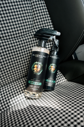 Blackline Car Care BLACKLINE® Reset interior cleaner and scent booster bottle beside a Porsche vehicle interior.