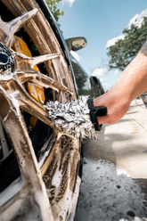 Blackline Car Care BLACKLINE® microfiber wheel mitt in use for cleaning car wheels, showing soft, plush microfiber material.