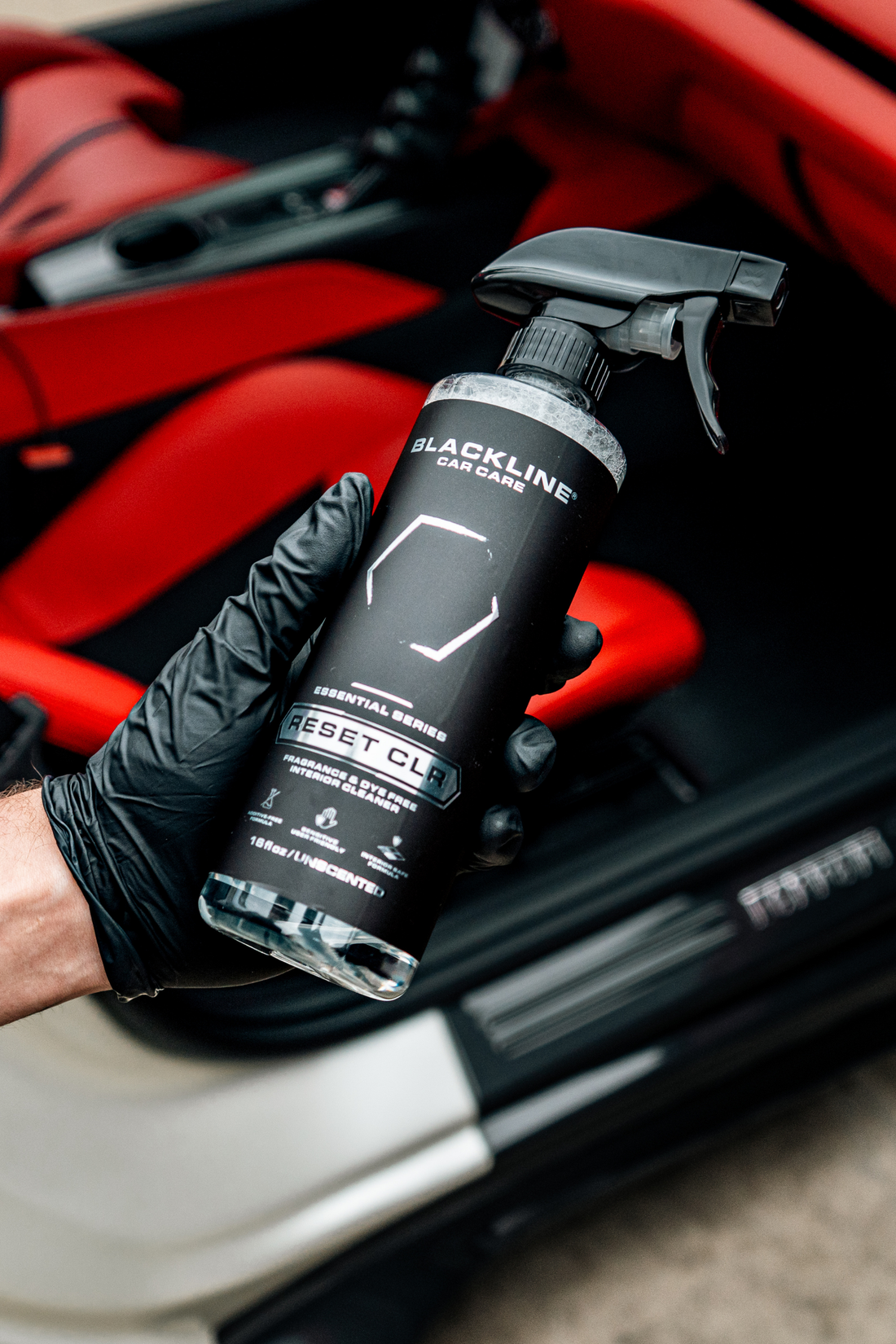 Blackline Car Care BLACKLINE® RESET interior cleaner and scent booster spray held in hand, showing product label and packaging.
