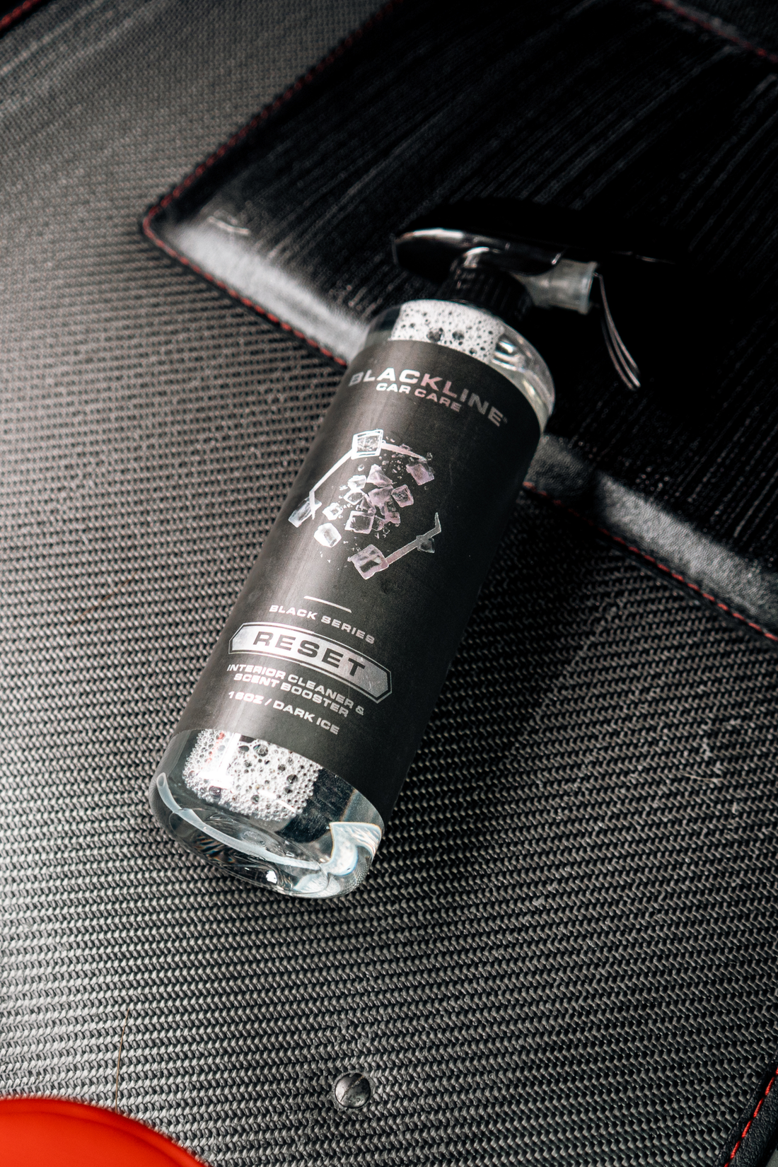 Blackline Car Care BLACKLINE® RESET interior cleaner and scent booster bottle on a dark ice floor mat.