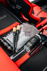 Blackline Car Care BLACKLINE® Reset interior cleaner and scent booster bottle inside a Ferrari F12 trunk, showcasing the product.