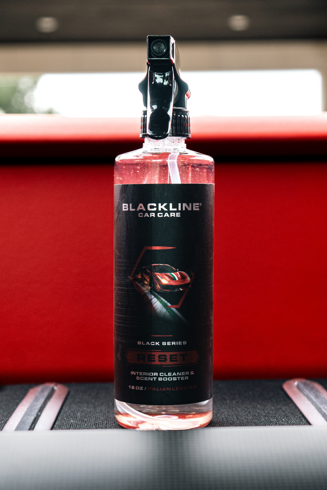 Blackline Car Care RESET interior cleaner and scent booster bottle with Italian leather scent, black label, and spray nozzle.