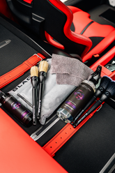 Blackline Car Care BLACKLINE® RESET interior cleaner and scent booster inside a Ferrari F12 trunk showing application tools and clean surfaces.
