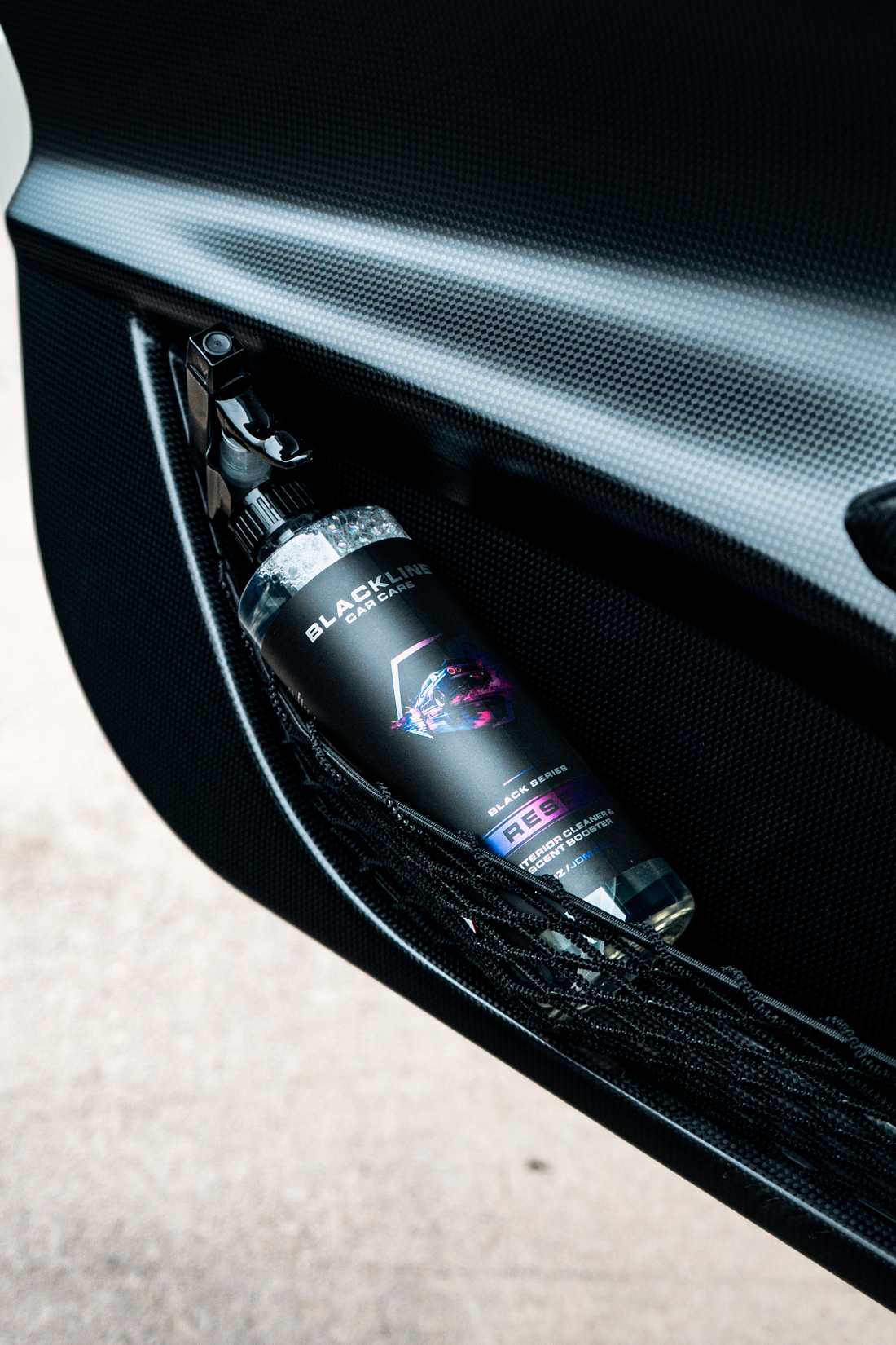 Blackline Car Care BLACKLINE® Reset interior cleaner and scent booster applied to a car door panel, showcasing its cleaning and freshening effect.