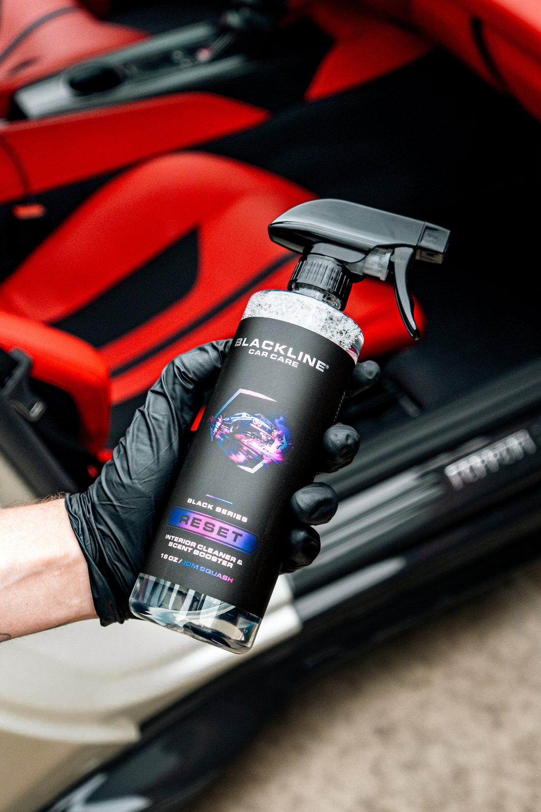 Blackline Car Care BLACKLINE® Reset interior cleaner and scent booster bottle held in hand, showcasing product packaging.
